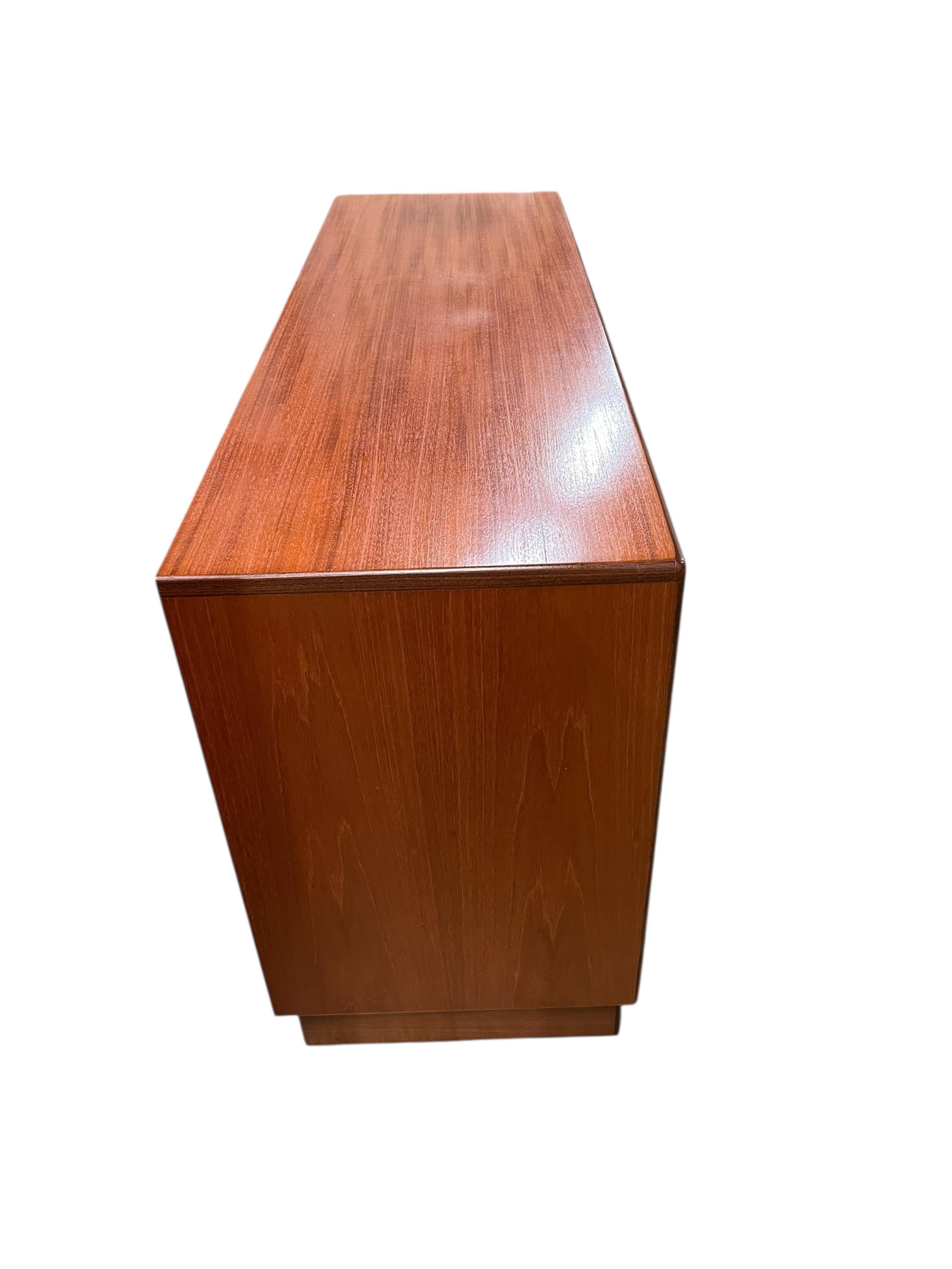 A mid century G Plan Fresco teak bedroom suite comprising a three door wardrobe, a two door wardrobe, two six drawer chests, dressing table, headboard and a pair of bedside chests